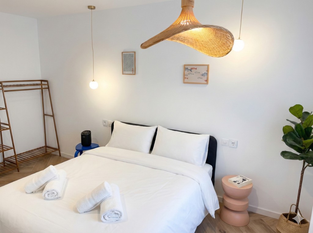 Dormitorio con cama doble y lámpara de rattan